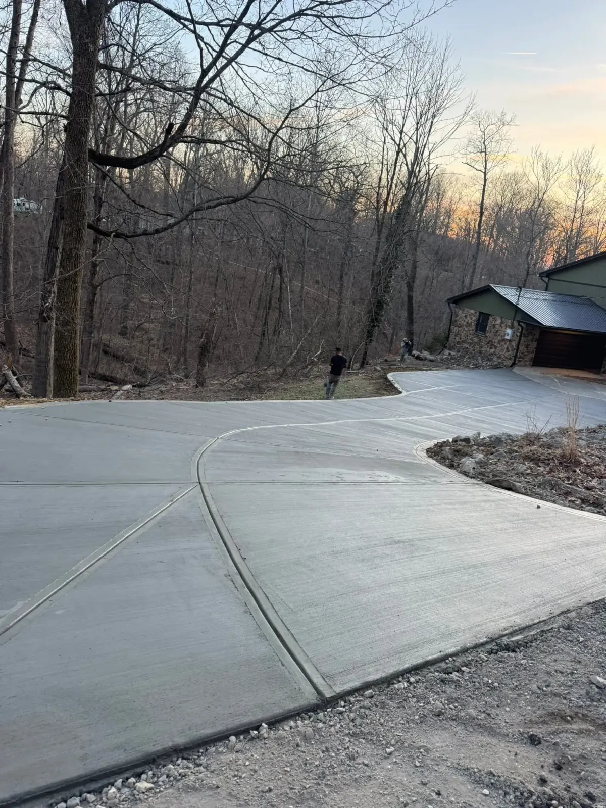Sweeping curved broom-finished concrete driveway by JD Concrete Solutions